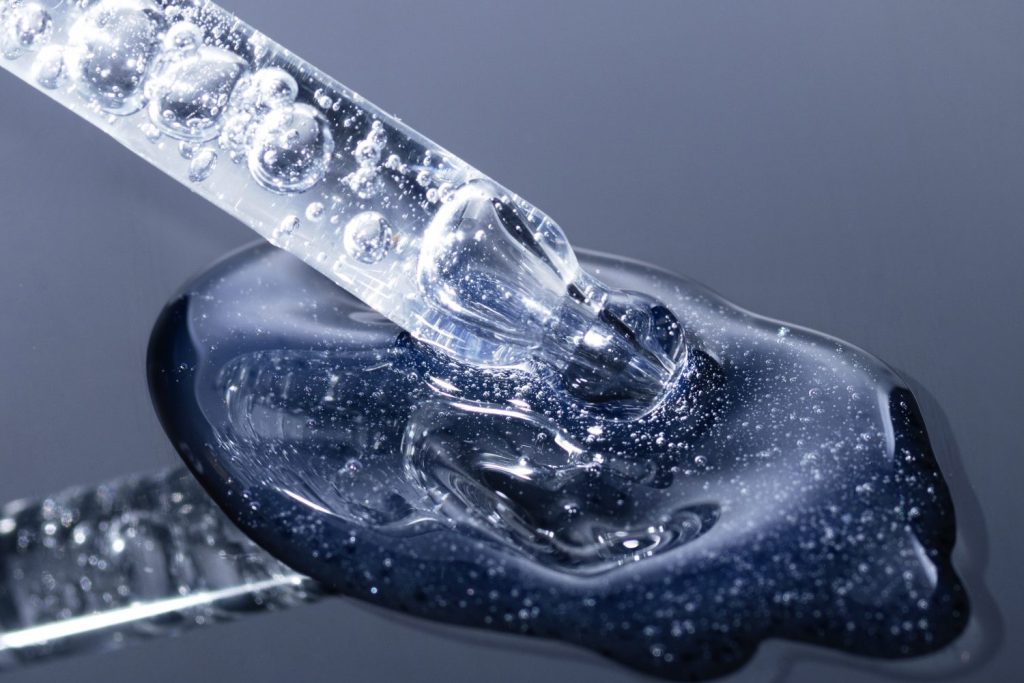 Bild Hyaluronsäure Pippette die einen Tropfen aufnimmt